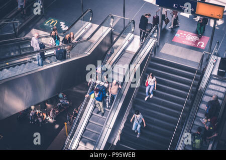 Berlin, Germany - july 2017: Traveling people with luggage on escalator inside main train station (Hauptbahnhof)   in Berlin, Germany