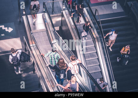 Berlin, Germany - july 2017: Traveling people with luggage on escalator inside main train station (Hauptbahnhof)   in Berlin, Germany