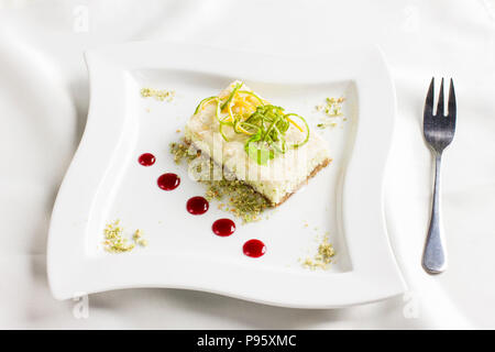Raw food dessert cake with lemon and lime candied fruits on white plate Stock Photo