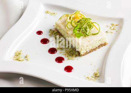 Raw food dessert cake with lemon and lime candied fruits on white plate Stock Photo