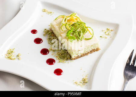 Raw food dessert cake with lemon and lime candied fruits on white plate Stock Photo
