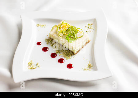 Raw food dessert cake with lemon and lime candied fruits on white plate Stock Photo