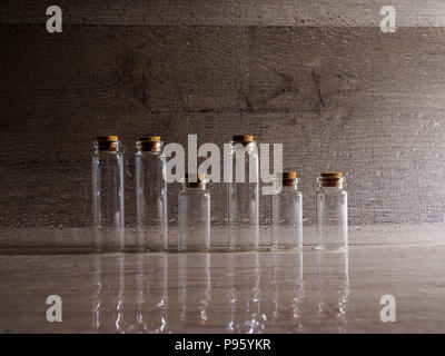 many small glass bottles used in medicine on paper background. Stock Photo