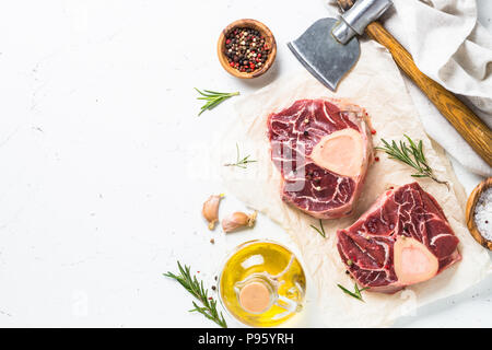 Fresh raw beef steak osso bucco with spices. Marble meat. Top view with copy space on white table. Stock Photo