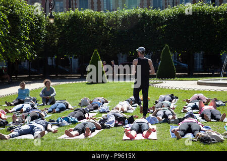 People doing Yoga in Place Des Vosges Park in Paris, France Stock Photo