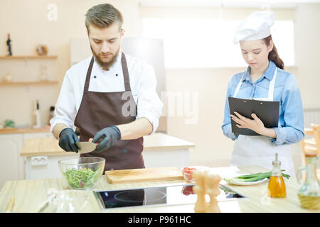 Young Chef Working in Restaurant with assistant Stock Photo