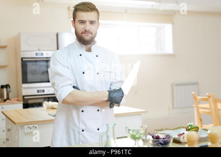 Handsome Professional Chef Posing in Kitchen Stock Photo