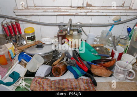 Pile of dirty utensils in a kitchen washbasin Stock Photo