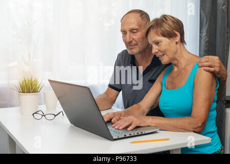 senior couple using laptop computer together at home Stock Photo