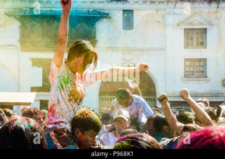 People throwing colored pigments during Hindu Holi festival of colors celebrations in Kathmandu Basantapur Durbar Square, Nepal Stock Photo