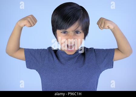 Angry kid screaming or yelling with raised arms and closed fists Stock Photo