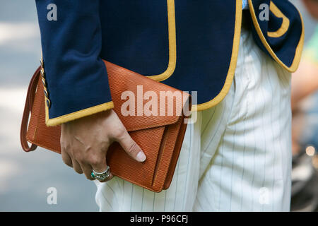 MILAN - JUNE 18: Man with Louis Vuitton bag in hand and Hermes