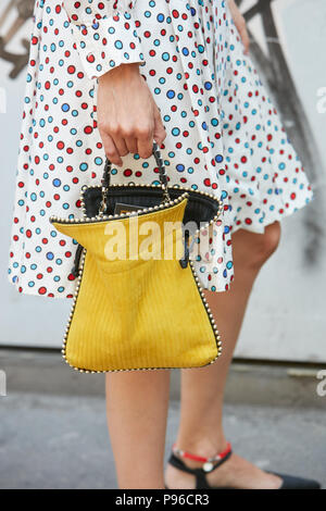 MILAN - JUNE 18: Woman with Fendi shirt and bag and golden Clou