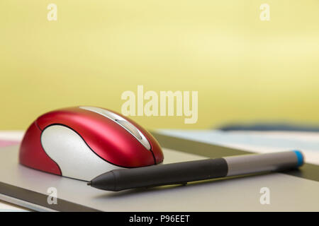 red wireless mouse and pencil, on a graphic tablet, computer peripherals Stock Photo