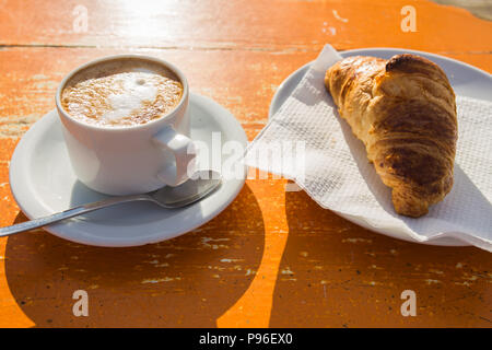 Cup of invigorating cappuccino and a croissant for breakfast Stock Photo
