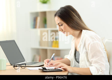 Side view portrait of a serious woman doing accounting at home Stock Photo