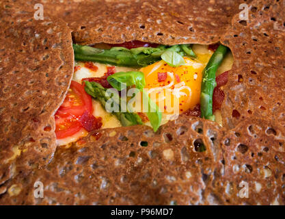 Close-up of a Breton buckwheat galette filled with fresh vegetables and an egg for lunch in Paris, France Stock Photo