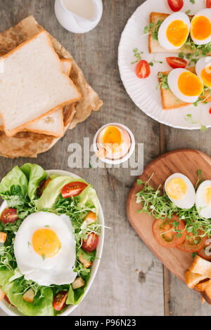 High Angle View of a Nutritious Vegetable Salad with Boiled Egg Slices, Served on a White Plate on Top of a Wooden Table Stock Photo