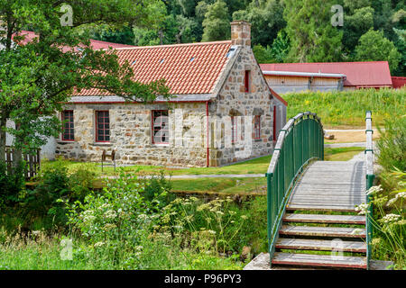 TRADITIONAL OLD WOOL MILL KNOCKANDO MORAY SCOTLAND THE RENOVATED BUILDINGS OF THE MILL AND LITTLE BRIDGE OVER THE STREAM Stock Photo