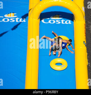 GENOA (GENOVA), ITALY, JULY, 7, 2018 - Two young boys playing in the longest water slide entered in the Guinness Book of Records showed for the Costa  Stock Photo