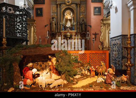 Christmas Manger scene with figurines including Jesus, Mary, Joseph, sheep and magi facing the altar in the christianity Church 'Iglesia de San Ildefo Stock Photo
