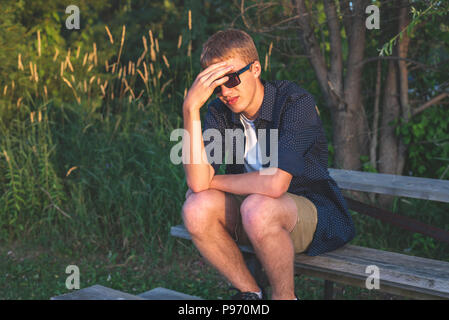 Upset teenager sitting on bleachers. Stock Photo