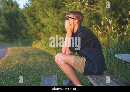 Upset teenager sitting on bleachers. Stock Photo