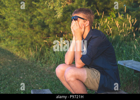Upset teenager sitting on bleachers. Stock Photo