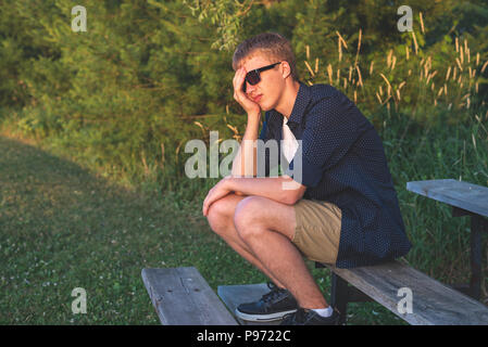 Upset teenager sitting on bleachers. Stock Photo
