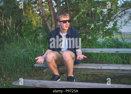 Confused teenager sitting alone on bleachers. Stock Photo