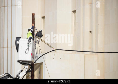 Telephone engineer working on overhead cables in city street in Spain Stock Photo