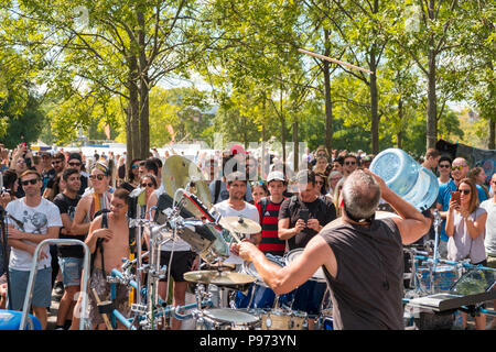 Berlin, Germany - july 2018: Many people in crowded Park (Mauerpark) watching  street performing / musician playing the drums on a sunny summer sunday Stock Photo