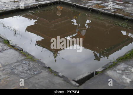 Kathmandu, Nepal. 15th July, 2018. Historic temples and people walking by are reflected on a puddle after a brief rainfall in Kathmandu, Nepal on Sunday, July 15, 2018. Credit: Skanda Gautam/ZUMA Wire/Alamy Live News Stock Photo