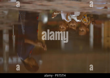 Kathmandu, Nepal. 15th July, 2018. Children are reflected on a puddle after a brief rainfall in Kathmandu, Nepal on Sunday, July 15, 2018. Credit: Skanda Gautam/ZUMA Wire/Alamy Live News Stock Photo