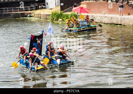 Cheshire, UK. 15th July 2018. A crew flying the flag of NHS School Nurses holds an advantage over RaftyMcRaftFace in a battle for supremacy in the raft race at the 2018 Northwich River festival. The School Nurses finished eventual overall runners up to the Northwich Plastics crew. The 2018 Northwich River Festival, organised by the Northwich Rotary Club, is the second staging of the event following its launch in 2017. Credit: Joseph Clemson, JY News Images/Alamy Stock Photo
