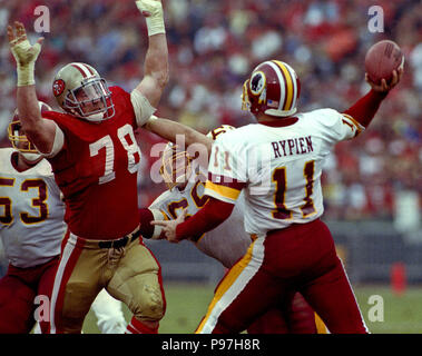 San Francisco, California, USA. 12th Jan, 1991. San Francisco 49ers vs  Washington Redskins at Candlestick Park Saturday, January 12, 1991. 49ers  beat Redskins 28-10. 49er linebacker Pierce Holt (78) rushes Redskin  quarterback Mark Rypien Credit: Al