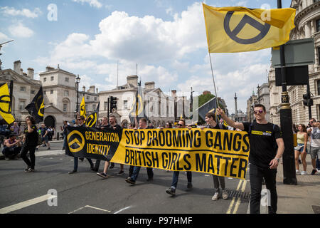London, UK. 14th July 2018. Members of the right-wing Generation Identity movement march down Whitehall to join the thousands of pro-Trump and 'Free Tommy Robinson' supporters in a mass rally. Credit: Guy Corbishley/Alamy Live News Stock Photo