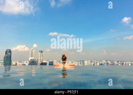 Female Tourist In Infinity Pool Of Marina Bay Singapore Stock Photo