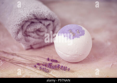 Natural cosmetics. Handmade lavender bath bombs, lavender flowers and towel on white wooden planks, top view Stock Photo