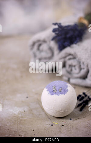 Natural cosmetics. Handmade lavender bath bombs, lavender flowers and towel on white wooden planks, top view Stock Photo
