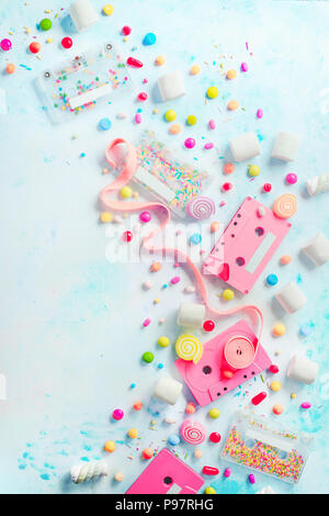 Pink cassette tapes in a sweet sounds concept. Candies, sprinkles and marmalades on a light background with copy space. Pastel color flat lay Stock Photo