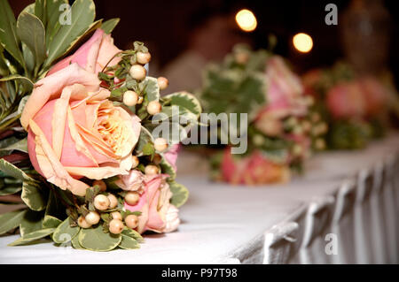 Bride and bridesmaid's bouquets lined up on reception table Stock Photo