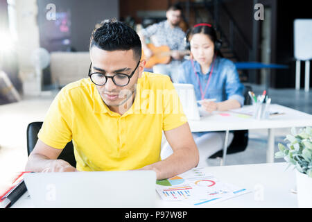 Young Middle Eastern Man Using Laptop in Office Stock Photo