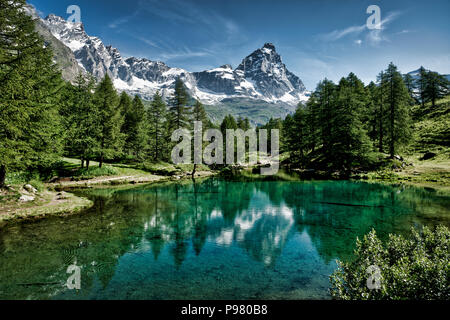 The blue lake and the Matterhorn in a scenic summer landscape with sunny lights seen from Breuil-Cervinia, Aosta Valley - Italy Stock Photo