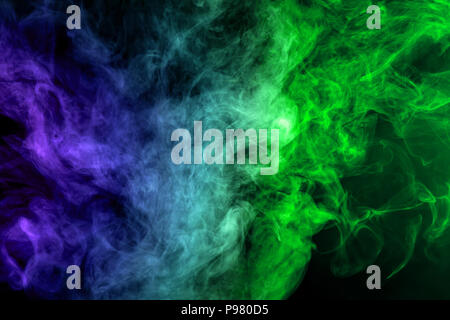Dense multicolored smoke of   blue and green colors on a black isolated background. Background of smoke vape Stock Photo