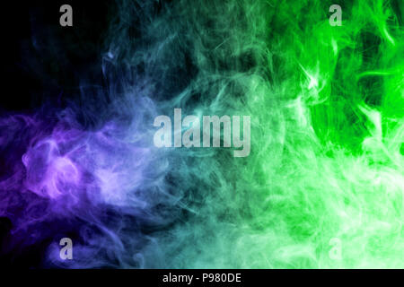 Dense multicolored smoke of   blue and green colors on a black isolated background. Background of smoke vape Stock Photo