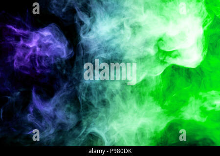 Dense multicolored smoke of   blue and green colors on a black isolated background. Background of smoke vape Stock Photo