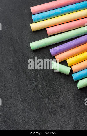 Row Pile of Multicolored Chalks Crayons on Dark Scratched Blackboard. Back to School Business Creativity Graphic Design Crafts Kids Concept. Poster Ba Stock Photo