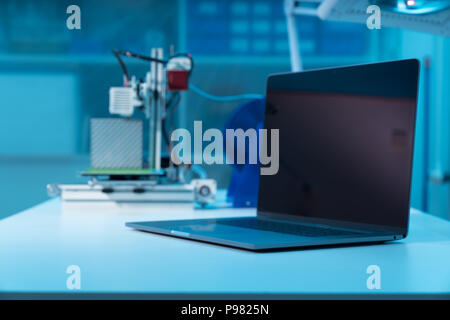 Computer and 3d printer on table in industrial design lab Stock Photo