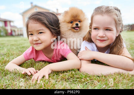 Two Little Girls with Cute Puppy Outdoors Stock Photo